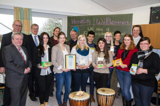 Die Fairtrade-Gruppe des Berufskollegs nimmt die Urkunde entgegen. Bürgermeister Ralf Péus, Schulleiter Willi Kruse, Geschäftsführerein Sr. Anna Maria Hovest, der kaufmännische Leiter Michael Bünger, Hartmut Köllner vom Eine-Welt-Laden in Meschede und der Fairtrade-Beauftragte Simon Martin freuen sich mit. Foto: SMMP/Bock