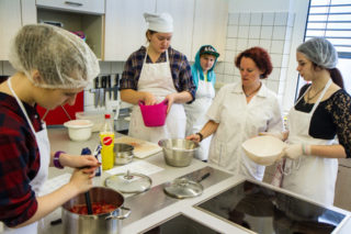 Fachlehrerin Eva Schönekäs (r.) bei der Arbeit mit den Schülerinnen und Schülern in der Küche. Foto: SMMP/Bock 