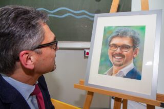 Gut getroffen: Michael Roth betrachtet das gemalte Portrait, das ihm das Lehrerkollegium zum Abschied überreichte. Foto. SMMP/Ulrich Bock